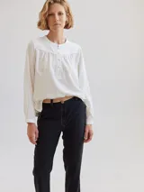 Camisa de diseño moderno y minimalista, sin cuello, con botones forrados y costuras en zig zag.