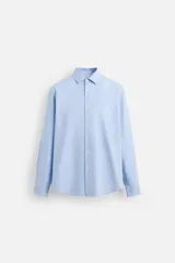 Camisa celeste de corte slim fit, confeccionada en algodón, con cuello italiano, manga larga y cierre frontal con botones.