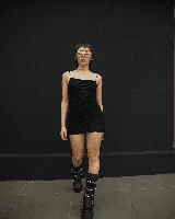Minivestido negro fruncido con breteles finos y tiras ajustables en los laterales.