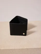 Billetera triplicable color marrón de cuero sintético con compartimentos internos.