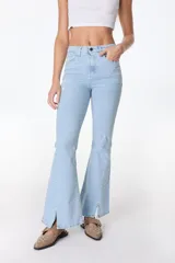 Pantalón jean negro de corte acampanado con aberturas en el ruedo.