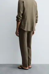 Pantalón de vestir color beige claro, de corte recto, confeccionado en lino.