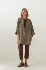 Tapado de largo medio, abierto, con cuello amplio. Prenda envivada con terminaciones en color marrón oscuro. Confeccionado en Uruguay con tela 100% lana fina sin teñir, diseñada exclusivamente por Don Baez.