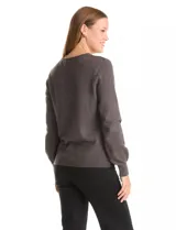 Buzo tejido color gris oscuro, con escote en V y manga larga. Presenta un aplique de tachas en la parte delantera.