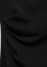 Vestido midi negro sin mangas, con cuello perkins, cintura drapeada y diseño evasé. Cierre de cremallera en la parte posterior y forro interior.