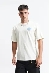 Remera oversize azul con estampado en la espalda que incluye una flor abstracta y la palabra 'blurred'.