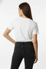 Remera color beige de algodón con cuello redondo y manga corta. Estampado con dos estrellas con patrón animal print y dos cerezas.