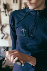 Remera térmica negra de manga larga, confeccionada en jersey de algodón grueso con vivos azules en contraste y logo bordado. Presenta cierre YKK en el cuello.