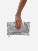 Sobre de fiesta negro charolado con cierre de solapa imantada y tira de cuero para sujetar a la muñeca.