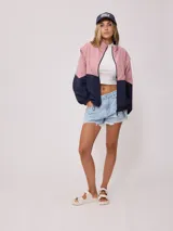 Campera negra tipo rompevientos de nylon con cierre frontal y bolsillos laterales.