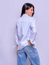 Camisa entallada de manga larga color rosa claro, con cuello clásico y cierre frontal con botones.