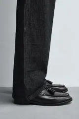 Mocasín de vestir color marrón oscuro, con detalle de borlas en la parte delantera, forro y plantilla interior a tono, horma redonda y suela con ligero tacón.