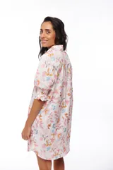 Vestido corto tipo camisero con estampado floral en tonos rosados, celestes y marrones. Tiene cuello camisero, mangas 3/4 abullonadas y cierre frontal con botones.