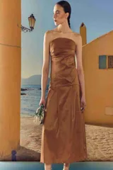 Falda midi color marrón terracota, de corte evasé con pliegues.