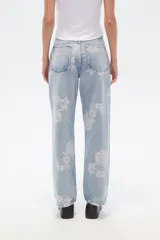 Pantalón de jean celeste con estampado de flores rosas, corte recto y tiro medio.