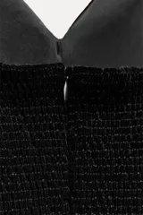 Vestido midi negro de terciopelo, palabra de honor con escote corazón y hombros descubiertos. Tiene detalle de elástico tipo nido de abeja en la espalda y abertura en el bajo.