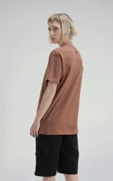 Remera color marrón claro de manga corta, cuello redondo y calce regular con recorte en espalda, realizada en algodón premium muy suave al tacto.