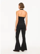 Pantalón negro acampanado confeccionado en j-tecno e fit flare, con cintura elástica, cierre lateral, recortes en el delantero y ruedo con godets que aportan amplitud.
