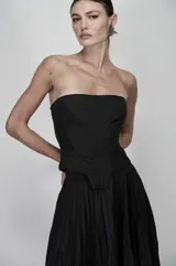 Corset negro strapless confeccionado en nylon técnico, con estructura definida y líneas geométricas marcadas.