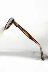 Lentes de sol estilo ojo de gato, montura negra brillante y lentes oscuros polarizados.