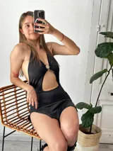 Minivestido negro con escote halter, abertura en el abdomen y tajo lateral.