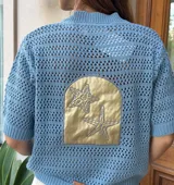 Saco de punto calado azul marino con aplique de cuero plateado bordado con dos estrellas de mar en la espalda.