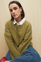 Sweater de punto color salmón con cuello redondo y mangas anchas. Presenta un diseño calado en la parte superior y tejido tramado horizontal en el resto del cuerpo.