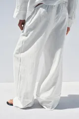 Pantalón palazzo de lino color rosado, con cintura elástica ajustable con cordón y bolsillos laterales ocultos.