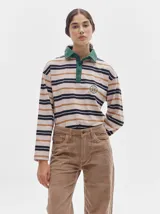 Remera polo de manga larga con rayas horizontales en blanco, rojo y verde. Cuello camisero rojo con cierre de dos botones y logo bordado en el pecho.