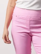 Pantalón capri color rosa de tencel elastizado con bolsillos simulados en la parte delantera y bolsillos aplicados en la parte trasera. Tiene pretina ancha, corte recto y terminación de ruedo desflecado.