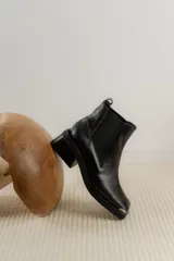 Botas Chelsea de cuero color marrón con elástico lateral negro, puntera metálica cuadrada y suela track.