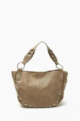 Cartera beige con tachas plateadas, doble asa de hombro con detalle trenzado y herrajes metálicos.