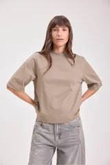 Remera color beige de corte cuadrado y mangas cortas.