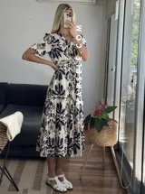 Vestido midi con estampado floral en tonos marrones y beige, corte camisero con cuello en V y botones frontales.