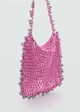 Bolso shopper grande color fucsia, con diseño trenzado y abalorios plateados irregulares. Tiene asa de hombro y no posee cierre.