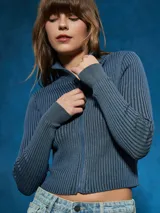 Campera azul de tejido de punto acanalado, con cuello alto, cierre frontal y mangas largas.