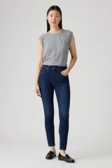 Pantalón de jean azul oscuro, tiro alto, corte skinny y tobillo al ras.