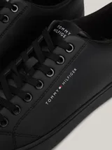 Zapatillas Tommy Hilfiger color negro, de cuero sintético, con cordones y suela plana.