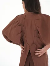 Camisa verde agua de lino, con botones de guampa, más larga atrás que adelante y espalda con tajo en el medio.