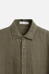 Camisa celeste de lino, de corte recto, manga larga y cuello clásico.