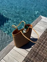 Bolso tipo tote de cuero color tostado, con diseño trenzado a mano.