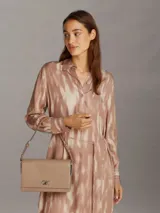 Cartera de hombro Calvin Klein color beige con logo plateado en el frente.