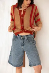 Camisa tejida a rayas horizontales color tostado y rojo, con cuello polo, mangas cortas y botones frontales.