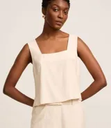 Blusa sin mangas color crema, confeccionada en viscosa, con escote cuadrado.