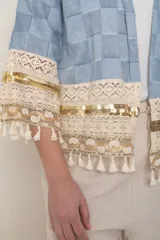 Chaqueta celeste con diseño a cuadros, sin forro, con apliques bordados en mangas y ruedo.