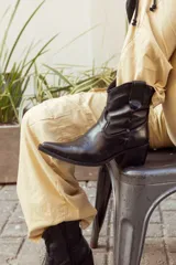 Bota texana corta negra de cuero, con taco de 5cm y detalles bordados en el empeine.