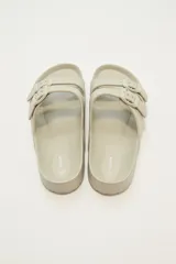 Sandalias tipo Birkenstock color beige con hebillas ajustables.