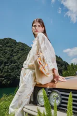 Camisa color crema con estampado de hojas en tonos beige, de corte crop, manga corta y cuello camisero.