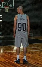 Musculosa deportiva gris con ribetes en cuello y sisas en negro y blanco. Estampado frontal con la palabra "RAVERS" y el número "90" en negro con borde blanco.