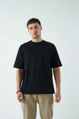 Remera oversize negra de algodón con cuello redondo y mangas cortas. Corte amplio y relajado.